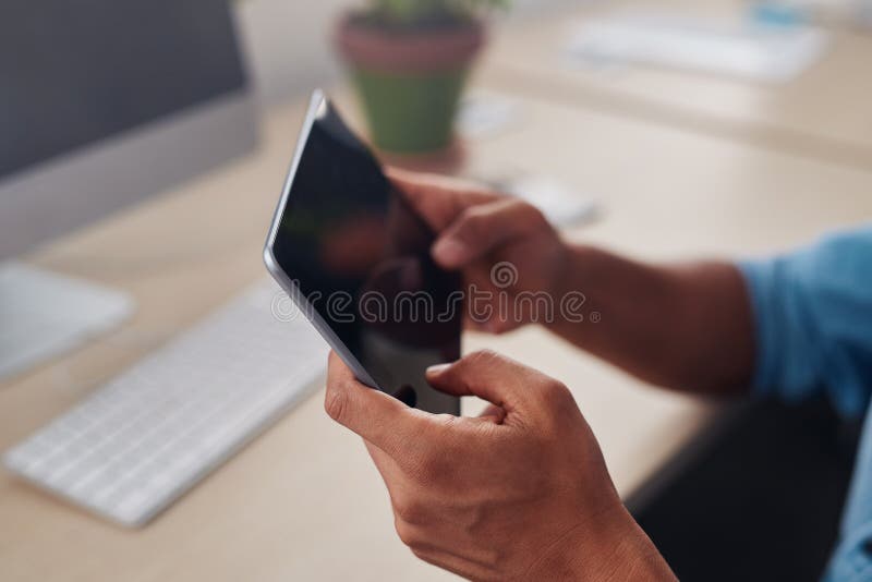 Designer sitting at his office desk using a tablet