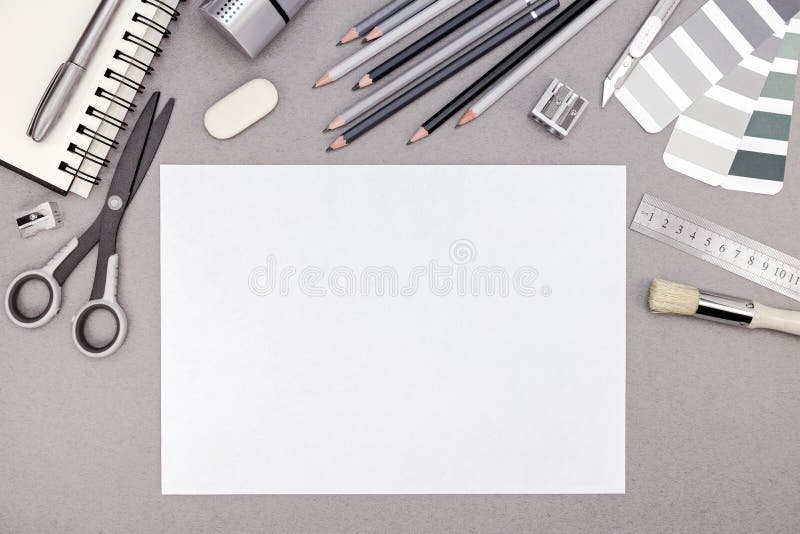 Designer workspace with blank paper, pencils, color swatches and