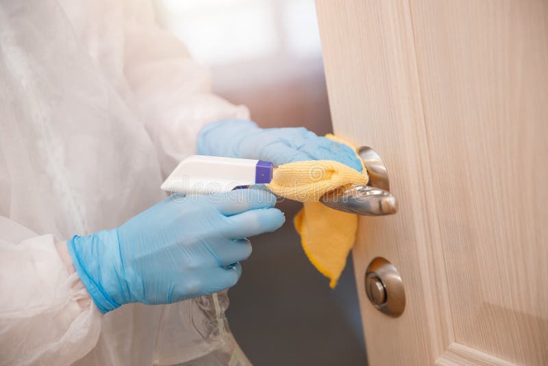 Desinfección y limpieza de los mangos de las puertas de la casa de la infección por virus y microbios en traje bioquímico Coronav