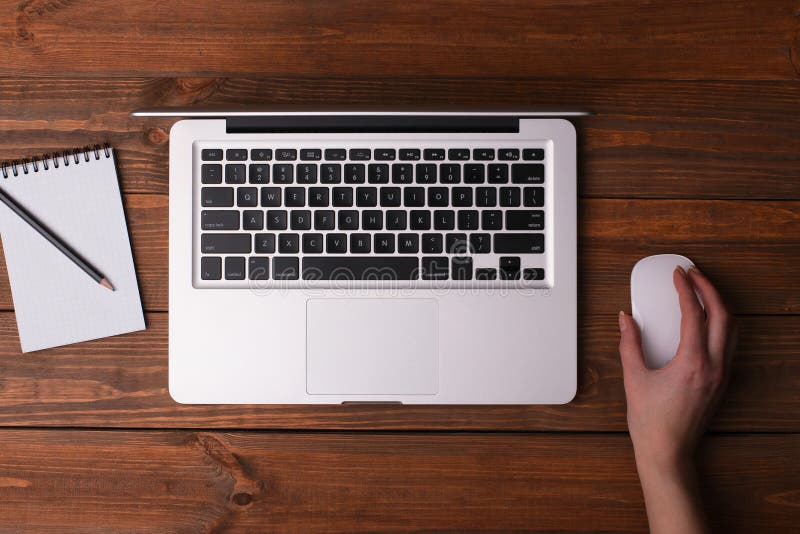 Desk with a laptop, a notebook with a pencil.