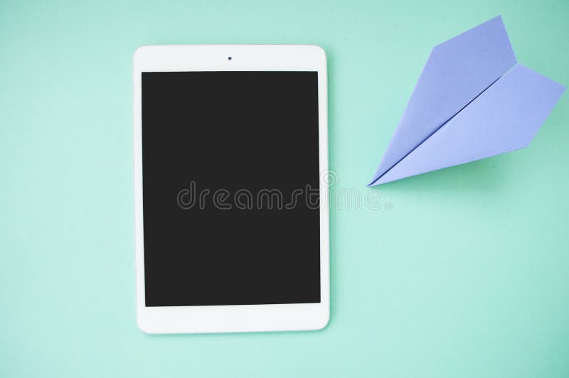 Desk with tablet and paper plane.