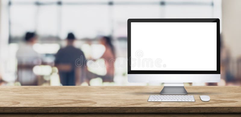 Desktop computer dello schermo in bianco sul piano d'appoggio di legno con il peop della sfuocatura