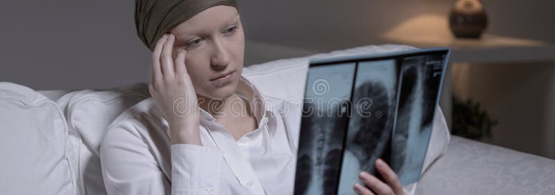 Despairing women with brain cancer looking at x-ray photo. Despairing women with brain cancer looking at x-ray photo