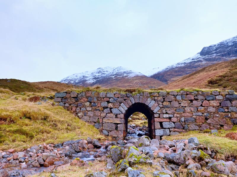 Despeje el río curvado de la corriente debajo del puente pedregoso viejo Trayectoria de las ovejas de montaña fotografía de archivo libre de regalías Despeje el río curvado de la corriente debajo del puente pedregoso viejo Trayectoria de las ovejas de montaña fotografía de archivo libre de regalías
