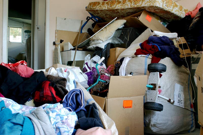 Junk and old clothes piled up in a garage. Junk and old clothes piled up in a garage