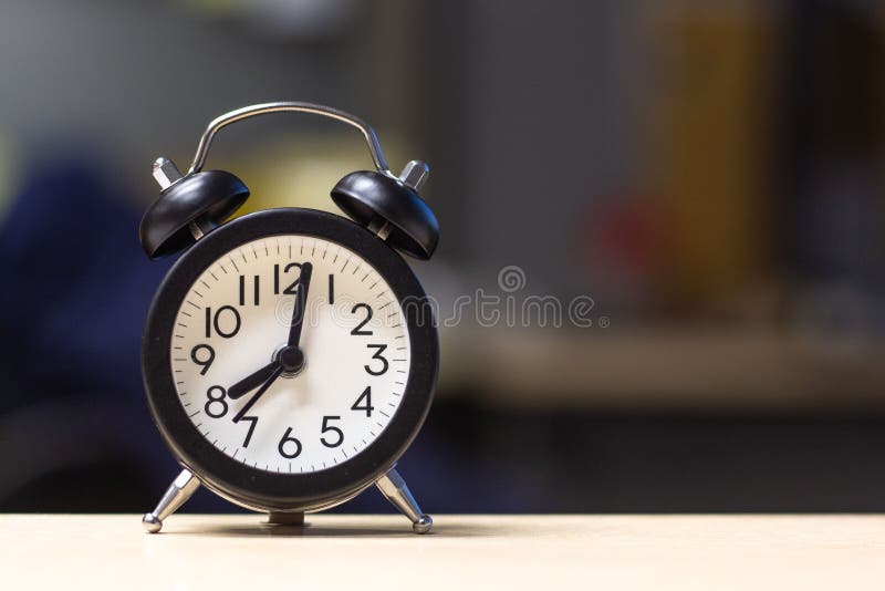 Despertador preto na tabela da mesa foto de stock Despertador preto na tabela da mesa foto de stock
