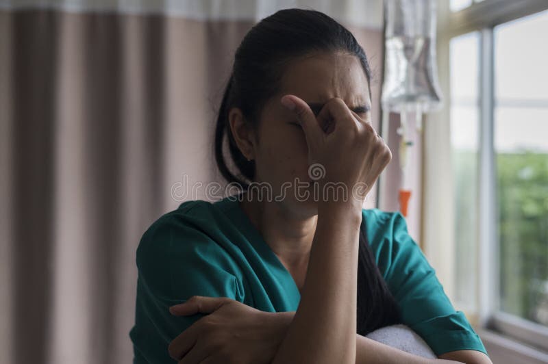 Despondent Asian woman patient. Following the doctor`s declaration that the cancer was nearing the end of its course