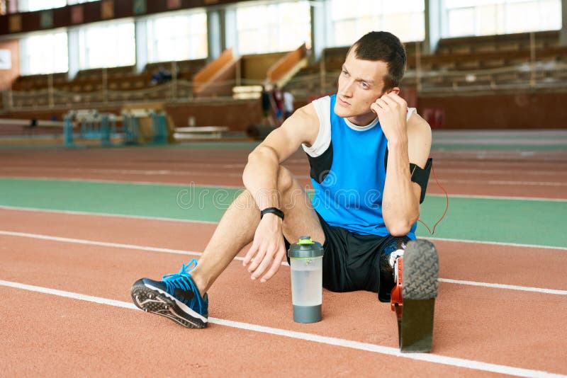 Desportista do amputado que descansa na pista de atletismo imagens de stock Desportista do amputado que descansa na pista de atletismo imagens de stock