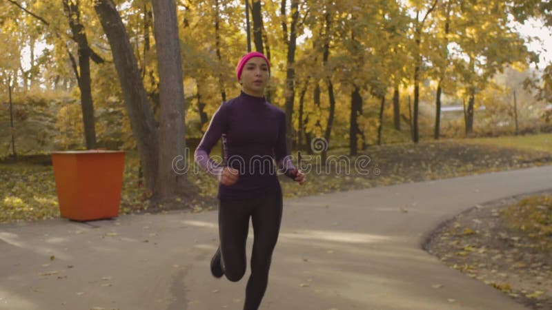 Desportista novo que corre ao longo da estrada