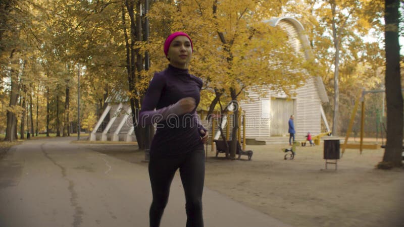 Desportista novo que corre ao longo da estrada