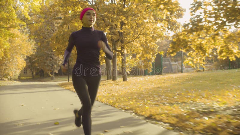 Desportista novo que corre ao longo da estrada