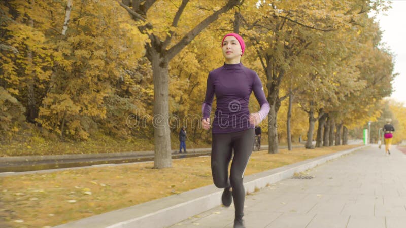 Desportista novo que corre ao longo da estrada