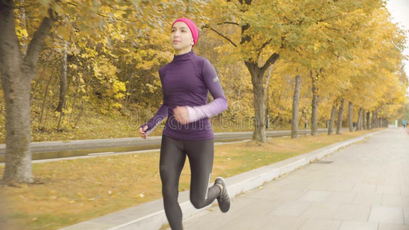 Desportista novo que corre ao longo da estrada