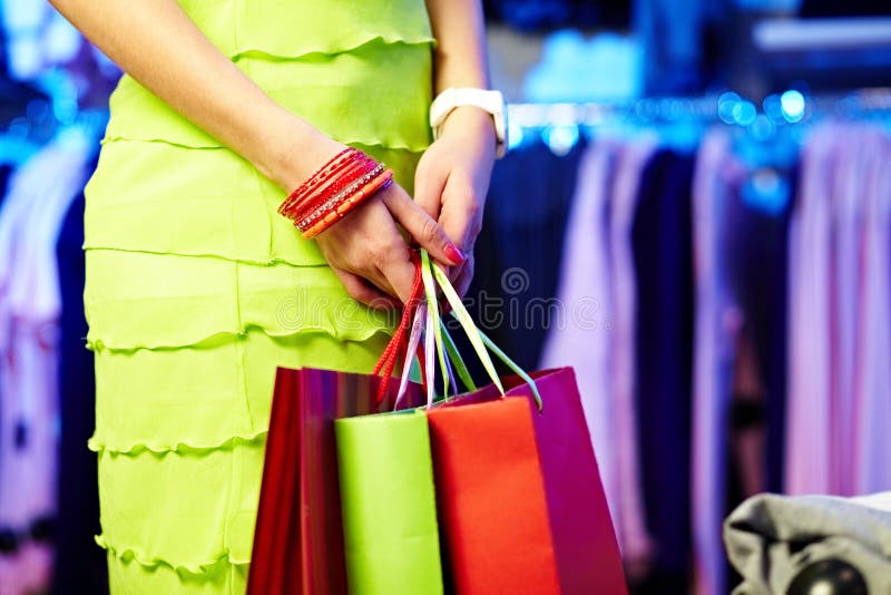 Image of shopaholic hands with three shopping bags. Image of shopaholic hands with three shopping bags
