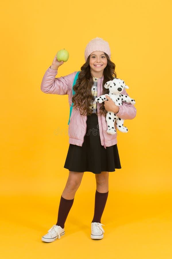 Dess äppelsäsong Äpple och leksak för skolbarn Ett litet barn med vitaminsnack Skolsnack Enjog snack arkivbild