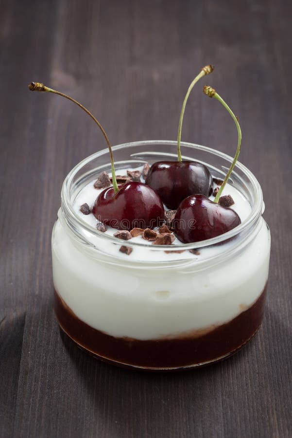 Dessert avec la confiture de crème et de cerise sur le fond en bois foncé photographie stock libre de droits Dessert avec la confiture de crème et de cerise sur le fond en bois foncé photographie stock libre de droits