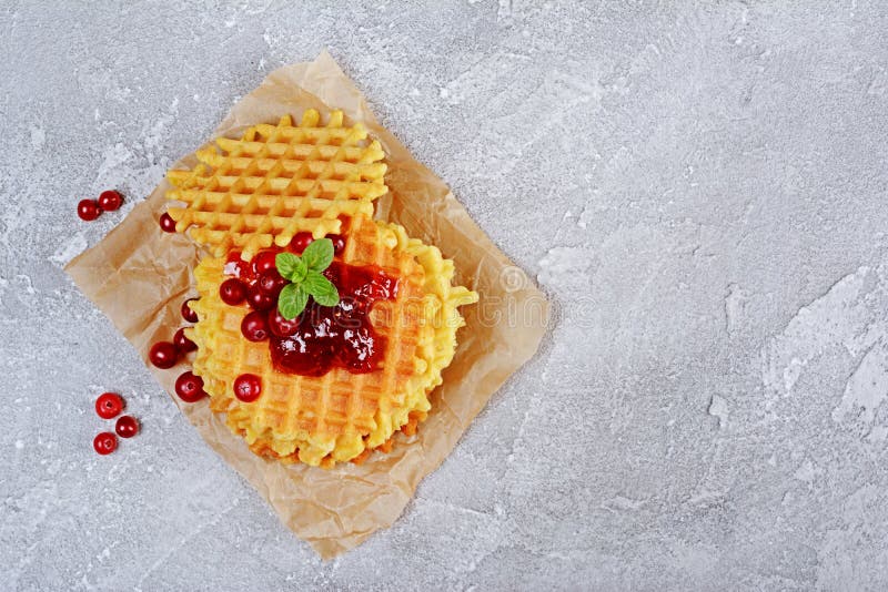 Dessert casalingo Cialde dolci con il mirtillo rosso, l'inceppamento e la menta freschi sulla carta pergamena fotografia stock Dessert casalingo Cialde dolci con il mirtillo rosso, l'inceppamento e la menta freschi sulla carta pergamena fotografia stock