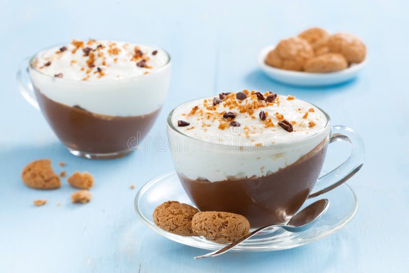 Dessert with chocolate, cream and amaretti on a blue table