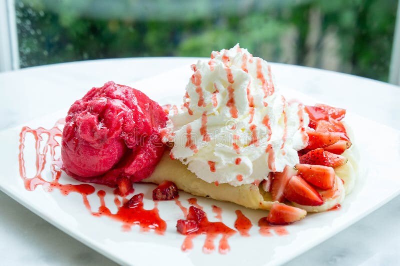 Dessert de crêpe de fraise de crème glacée sur la table en bois de plat blanc dans c image libre de droits Dessert de crêpe de fraise de crème glacée sur la table en bois de plat blanc dans c image libre de droits