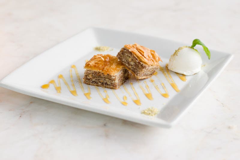 Baklava and ice-cream on white plate on white. Baklava and ice-cream on white plate on white