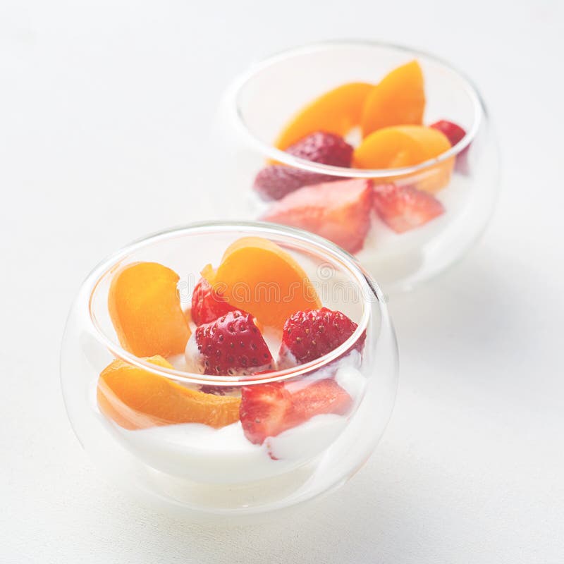 Dessert sain de vitamine légère de la fraise, de l'abricot et des cornflakes coupés en tranches avec de la crème dans des crémeus photographie stock libre de droits