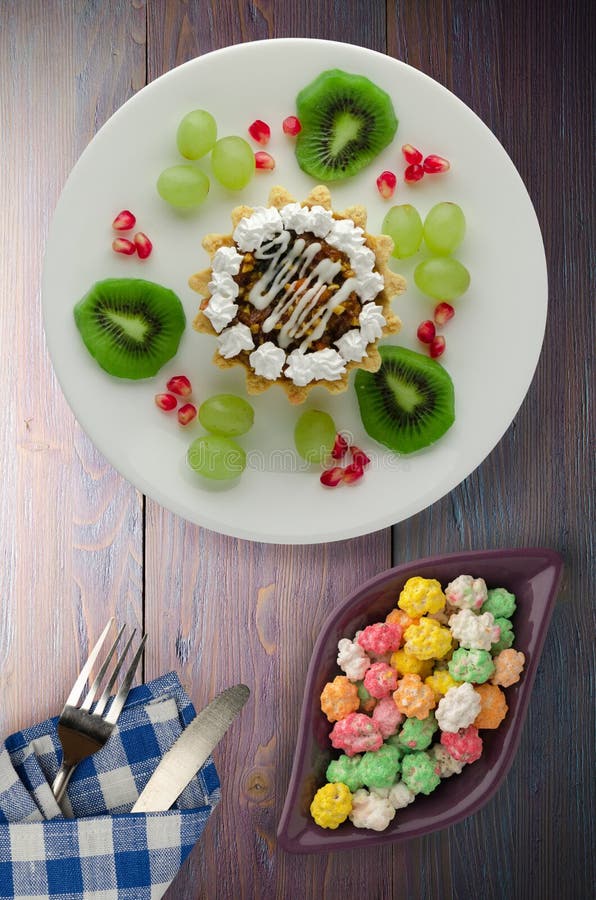 Dessert van cake en fruitdruiven, kiwi, granaatappel op een woode royalty-vrije stock foto's Dessert van cake en fruitdruiven, kiwi, granaatappel op een woode royalty-vrije stock foto's
