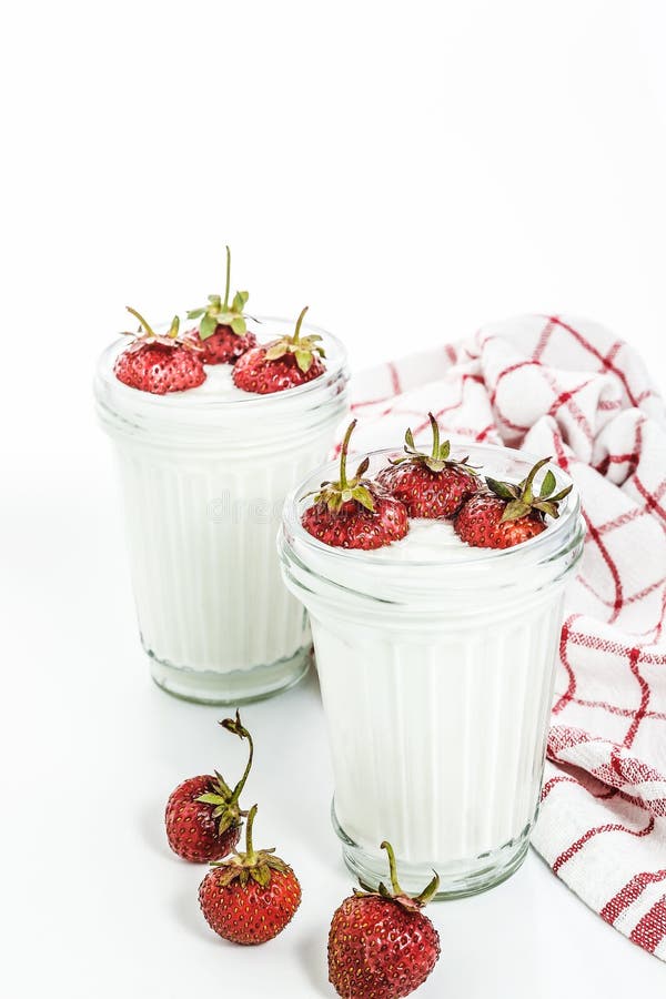 Dessert yogurt and strawberry layers in a glass on a red striped