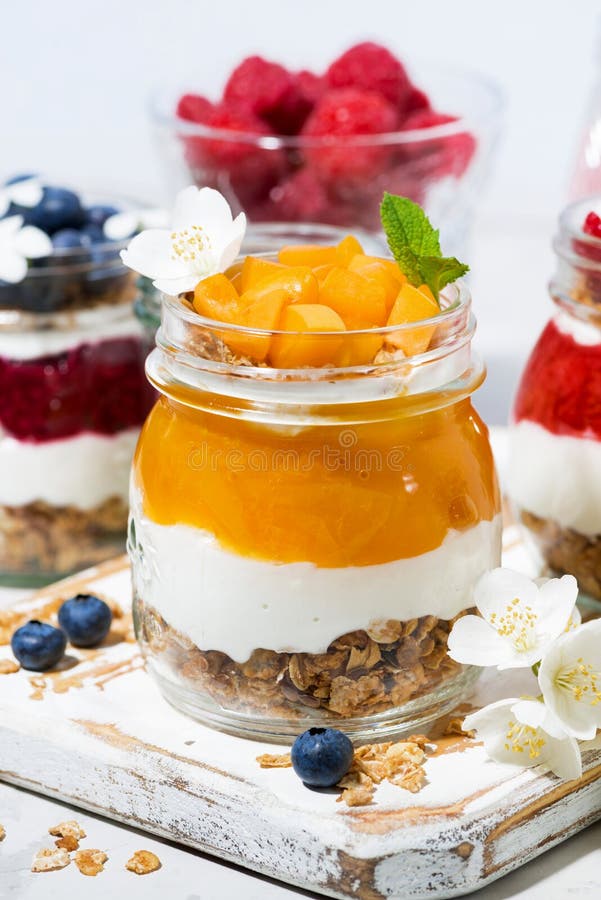 Desserts with Muesli, Berry Puree and Fruit in Jars, Vertical Stock