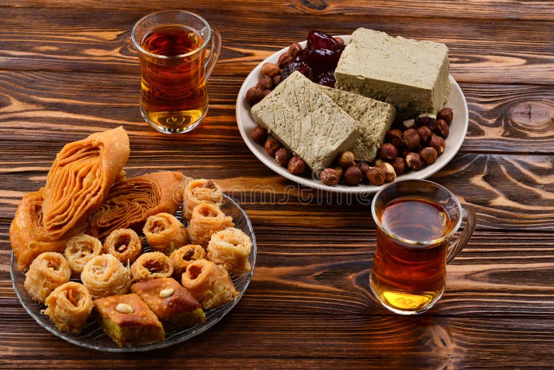 Desserts orientaux traditionnels assortis avec le thé sur le fond en bois image stock Desserts orientaux traditionnels assortis avec le thé sur le fond en bois image stock