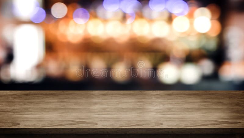 Dessus de table en bois avec le compteur de barre de boîte de nuit de tache floue avec la lumière de bokeh