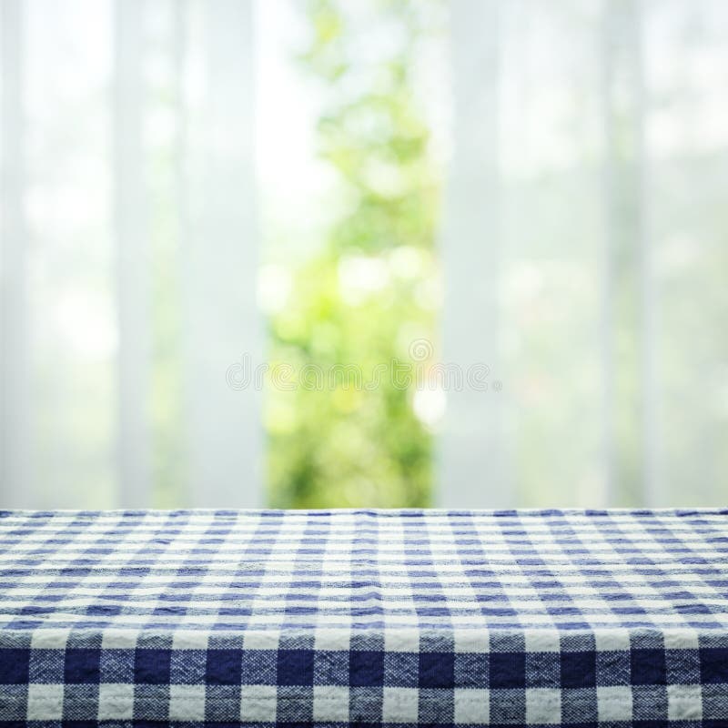 Checkered tablecloth texture top on blur of curtain with window view green from tree garden background.For montage product display or design key visual layout. Checkered tablecloth texture top on blur of curtain with window view green from tree garden background.For montage product display or design key visual layout