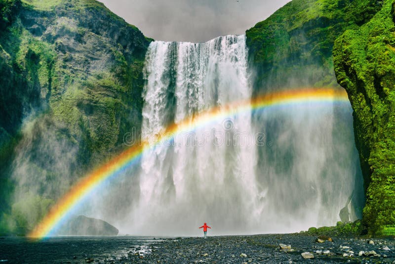 Destinazione turistica famosa della natura di viaggio della cascata dell'Islanda Cascata di Skogafoss con l'arcobaleno e la donna