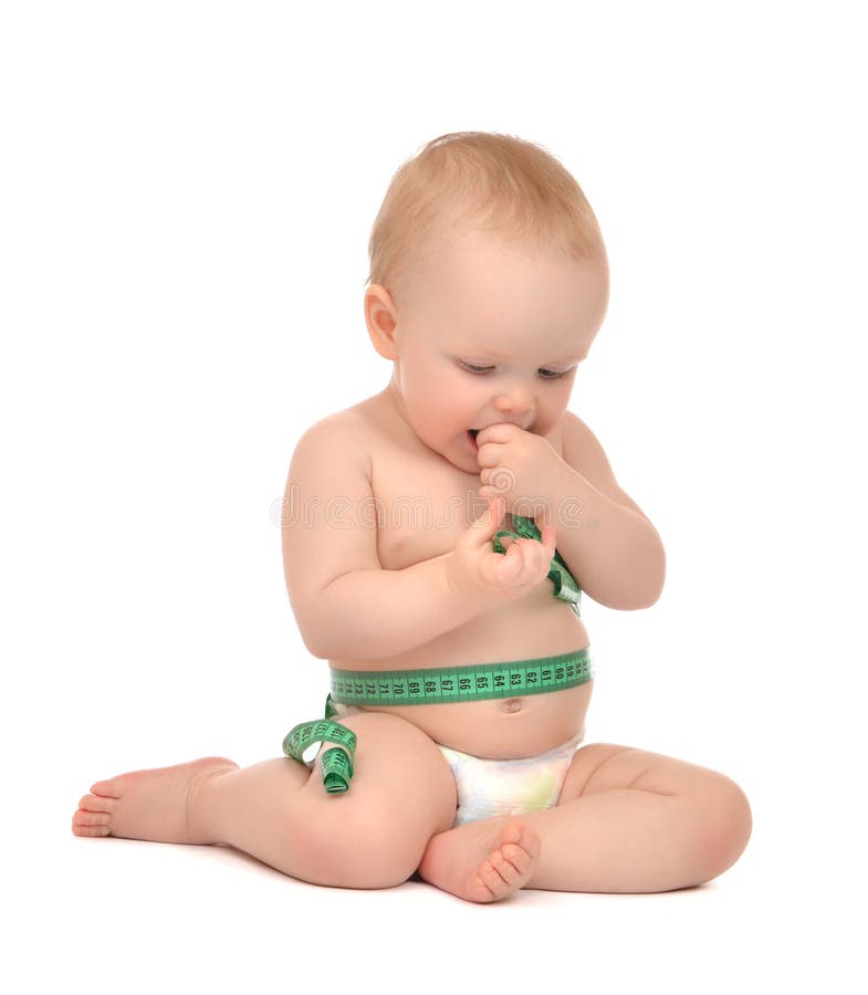 Infant child baby toddler sitting playing with tape measure measuring body isolated on a white background. Infant child baby toddler sitting playing with tape measure measuring body isolated on a white background