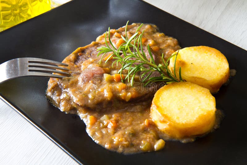 Det bräserade köttet med polenta arkivfoton