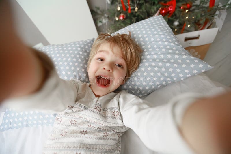 Det dekorerade julgransträdet står i rummet nära den säng där barnet ligger royaltyfri foto