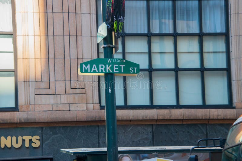 Det gröna Market Street tecknet på en grön pol med ett stort mång--förser med rutor fönstret på en gammal kontorsbyggnad i bakgru royaltyfri foto Det gröna Market Street tecknet på en grön pol med ett stort mång--förser med rutor fönstret på en gammal kontorsbyggnad i bakgru royaltyfri foto