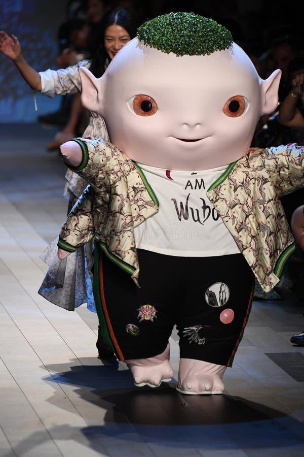 Det gulliga lilla monstret Wuba och formgivaren Vivienne Tam går landningsbanan royaltyfria foton Det gulliga lilla monstret Wuba och formgivaren Vivienne Tam går landningsbanan royaltyfria foton