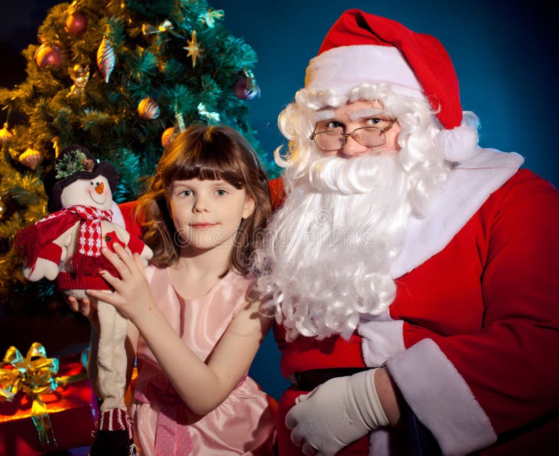 Det Jultomte innehav hänger lös och liten flickainnehavtoyen arkivfoton Det Jultomte innehav hänger lös och liten flickainnehavtoyen arkivfoton
