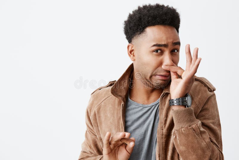 Det luktar egentligen bad Stäng sig upp ståenden av den unga roliga mörkhyade mannen med den afro frisyrbokslutnäsan med fingrar royaltyfria bilder Det luktar egentligen bad Stäng sig upp ståenden av den unga roliga mörkhyade mannen med den afro frisyrbokslutnäsan med fingrar royaltyfria bilder