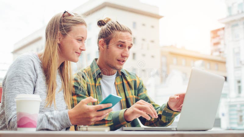 Det lyckliga barnet kopplar ihop sammanträde i kafé med bärbara datorn och diskuteraplan tillsammans, den förvånade mannen som se arkivfoto Det lyckliga barnet kopplar ihop sammanträde i kafé med bärbara datorn och diskuteraplan tillsammans, den förvånade mannen som se arkivfoto
