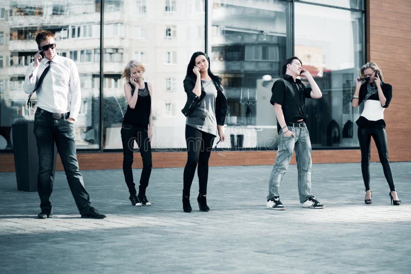 Group of young fashion men and women calling on the mobile phones. Group of young fashion men and women calling on the mobile phones