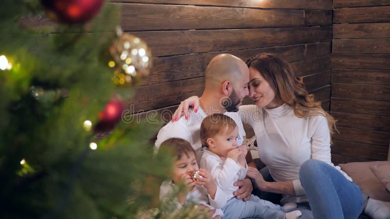 Det nya året tycker om lyckliga föräldrar med två charmiga barn familjkomfort nära till julträdet lager videofilmer
