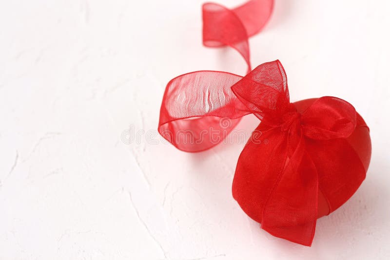 Det röda easter ägget med bandet, på vit texturerade yttersida arkivbilder Det röda easter ägget med bandet, på vit texturerade yttersida arkivbilder
