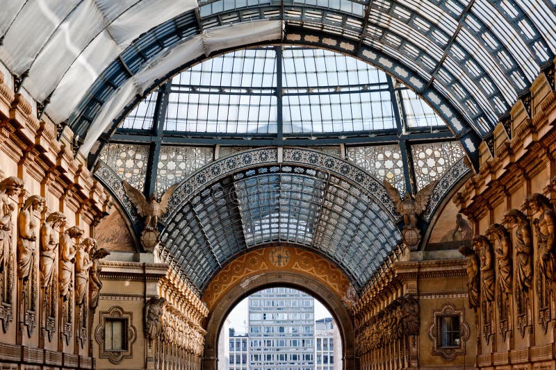 The arching glass and cast iron roof of Galleria Vittorio Emanuele II in Milan, Italy. Built in 1875 this gallery is one of the most popular landmarks and luxury shopping areas in the city. The arching glass and cast iron roof of Galleria Vittorio Emanuele II in Milan, Italy. Built in 1875 this gallery is one of the most popular landmarks and luxury shopping areas in the city