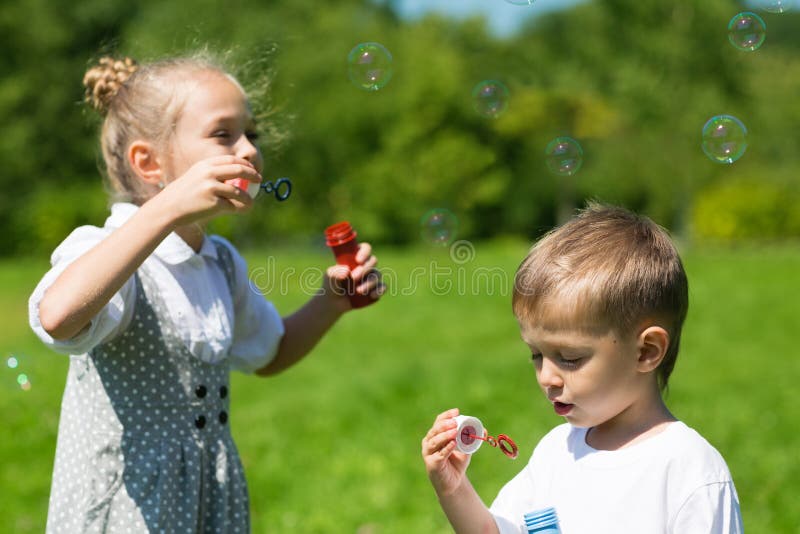Det älskvärda ungeslaget bubblar i parkera royaltyfri bild Det älskvärda ungeslaget bubblar i parkera royaltyfri bild