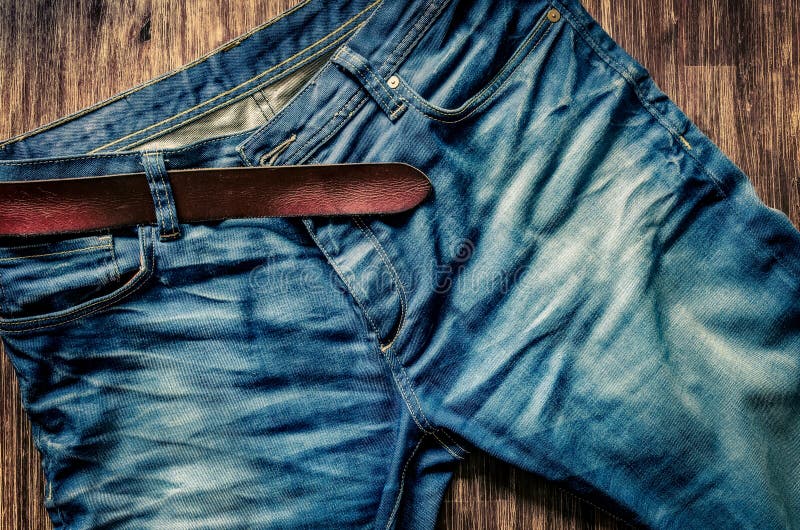 Detail of blue jeans with leather belt in vintage style stock photography
