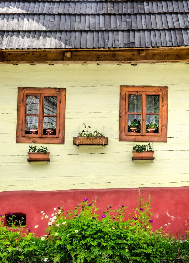 Detail of colorful windows with flowers on old traditional house