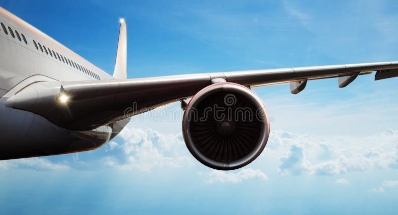 Detail of commercial airplane flying above clouds