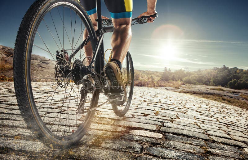 Detail of cyclist man feet riding mountain bike on outdoor trail on country road