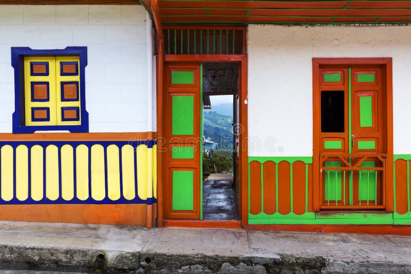Detail of the door and windows of a house painted in bright colors in the town of Salento, in Colombia